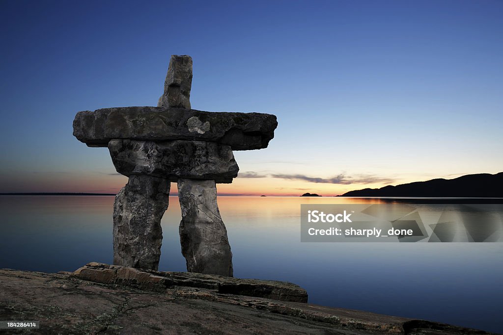 XL inukshuk twilight inukshuk in silhouette on hilltop overlooking lake at twilight (XL) Canada Stock Photo