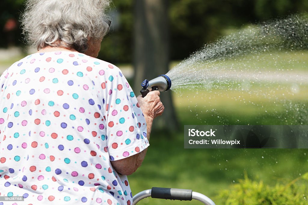 Senior Frau sprühen Wasser Spritzen mit Garten - Lizenzfrei 80-89 Jahre Stock-Foto