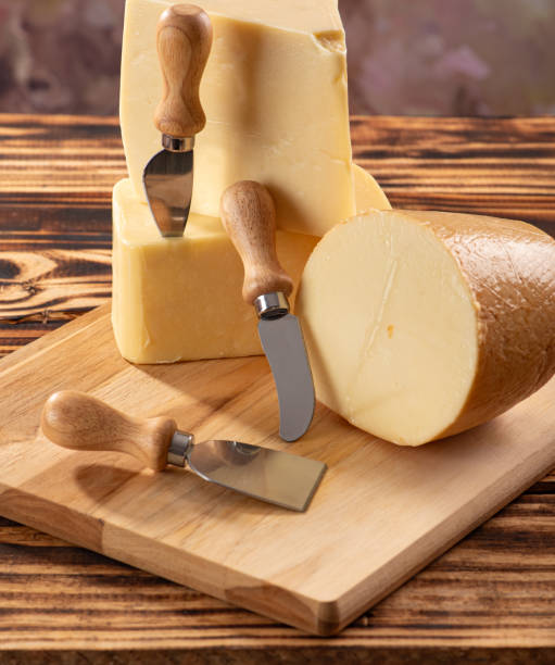istock Cheeses, beautiful pieces of cheese and accessories placed on rustic wood, light background, selective focus. 1842879657