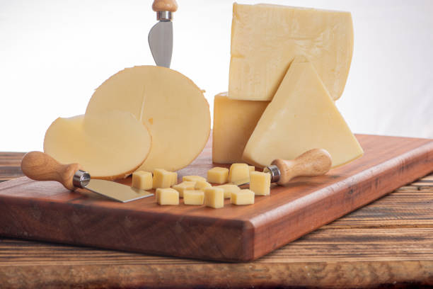 istock Cheeses, beautiful pieces of cheese and accessories placed on rustic wood, light background, selective focus. 1842880743