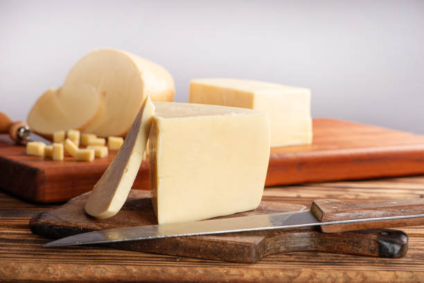 istock Cheeses, beautiful pieces of cheese and accessories placed on rustic wood, light background, selective focus. 1842881274