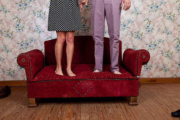 giovane coppia saltando sul divano vecchio - valentines day love nerd couple foto e immagini stock