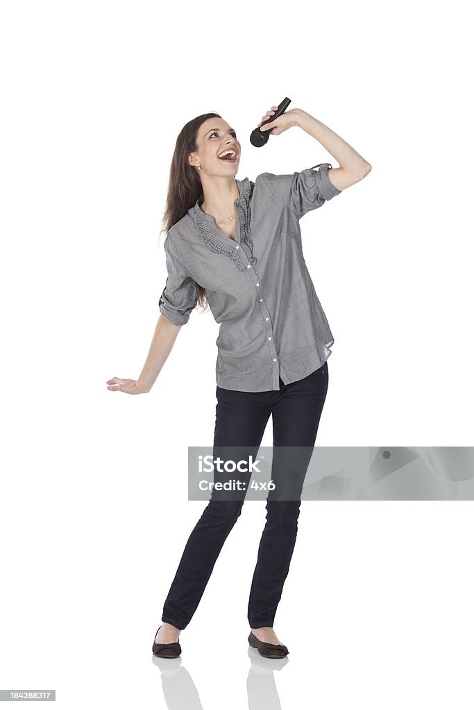 Beautiful woman singing into a microphone Beautiful woman singing into a microphonehttp://www.twodozendesign.info/i/1.png Singing Stock Photo