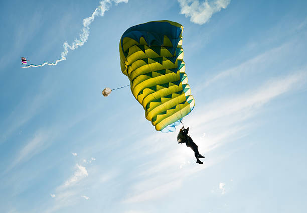 istock Parachutist going down in the sky with blu-yellow ram-hair parachute 184288764