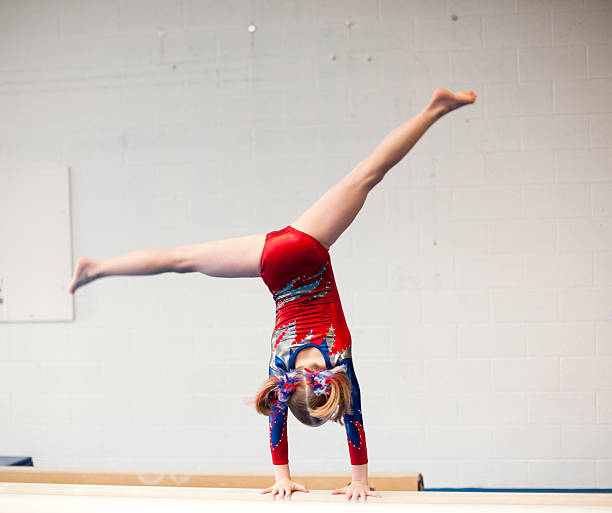 istock Young Gymnast Performs Cartwheel on Balance Beam 184288875