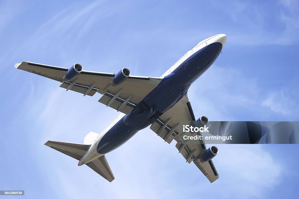 Boeing 747-400 desde abajo contra el cielo azul con nubes de luz - Foto de stock de Reino Unido libre de derechos