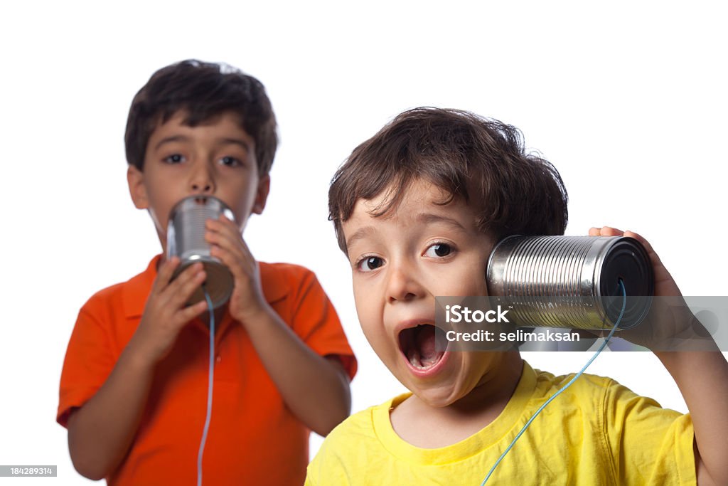 Due ragazzini parlando e la comunicazione al Telefono di latta - Foto stock royalty-free di Telefono di latta