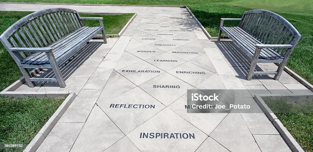 Inspiration Walkway Path embedded with inspirational word concepts, flanked by wooden benches, Lewis Ginter Botanical Garden, Richmond, Virginia. Horizontal. Bench Stock Photo