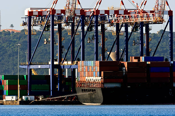 nave mercantile in un porto di carico off da gru. - gregg foto e immagini stock