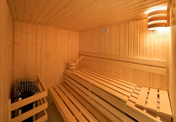 sauna in luxury home "a home sauna in a luxury new house brand new and ready for use. The interior comprises sanded pine panels and seating, a hot-coal steamer, a bucket with wooden spoon to apply water and a thermoter on the wall.Please see my other Interior and Architectural images by clicking on the Lightbox link below...A>AA>A" swedish sauna stock pictures, royalty-free photos & images