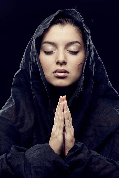 istock young woman with hoody and folded hands thinking 184291071