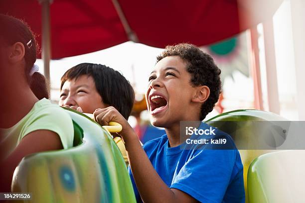 Bambini Cavalcare Un Ottovolante - Fotografie stock e altre immagini di Montagne russe - Montagne russe, Bambino, Gridare