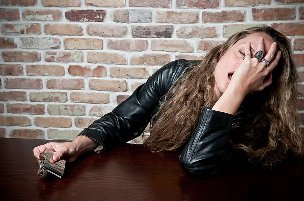 istock drunken woman with empty hip flask 184291771