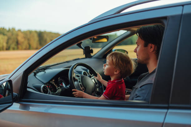 istock Father with his two year old son driving car in a field 1842918285
