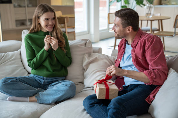 istock Romantic surprise. Happy wife look at husband unpacking present gift box smiling expecting reaction 1842918806