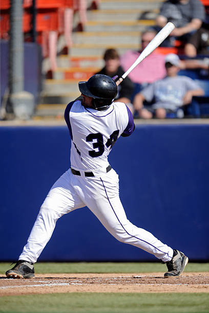 Baseball player swinging his bat a man hitting a ball baseball player photos stock pictures, royalty-free photos & images