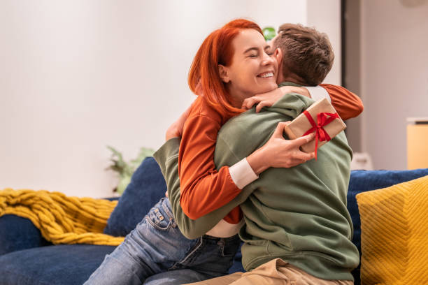 istock Happy young woman hugging loving husband, feeling grateful for gift in wrapped gift box 1842927765