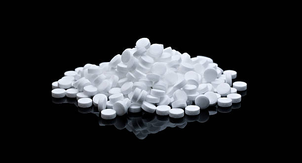 white pills on black background stock photo