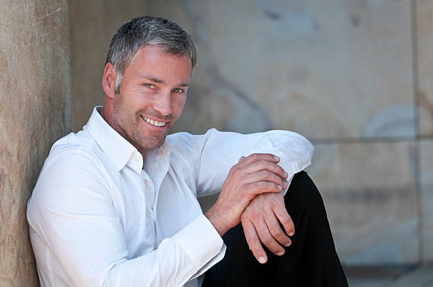 istock smiling businessman leaning at wall 184294016