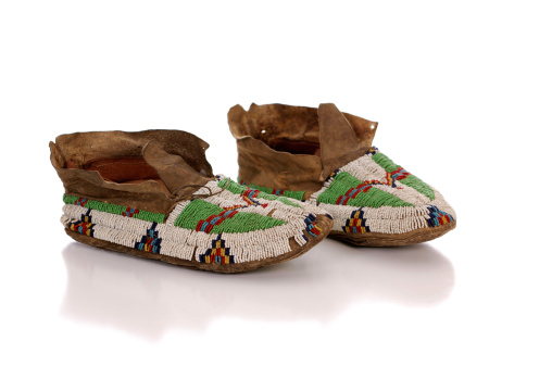 A pair of beautiful rare antique Native American hand beaded moccasins on white.