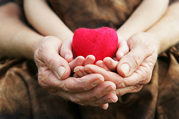 A child and grandmother's hands cradling a small felted heart (made by me).