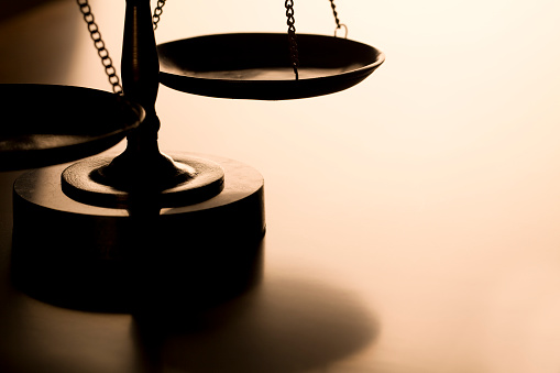 Scales of justice with back-light on wood table. Ideal for home page of law firm website. Can flop and add text as well.