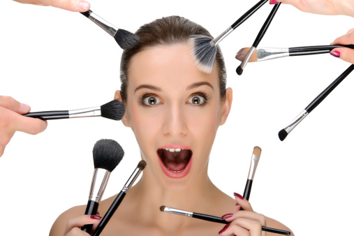 woman portrait surrounded by make up brushes.