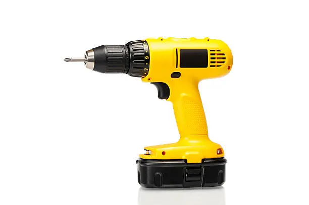 Photo of Cordless yellow power drill isolated on a white background
