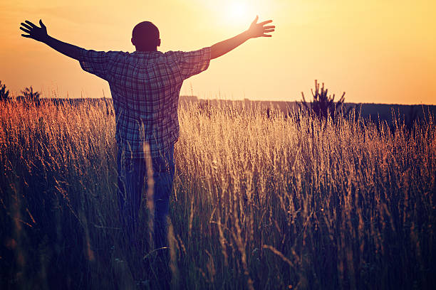 istock Man on the meadow prays to God 184294467