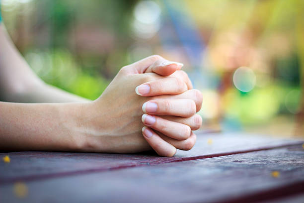 istock Woman sitting at table with hands clasped 184294758