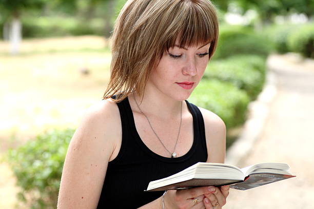 istock Attractive girl student reading book 184294810