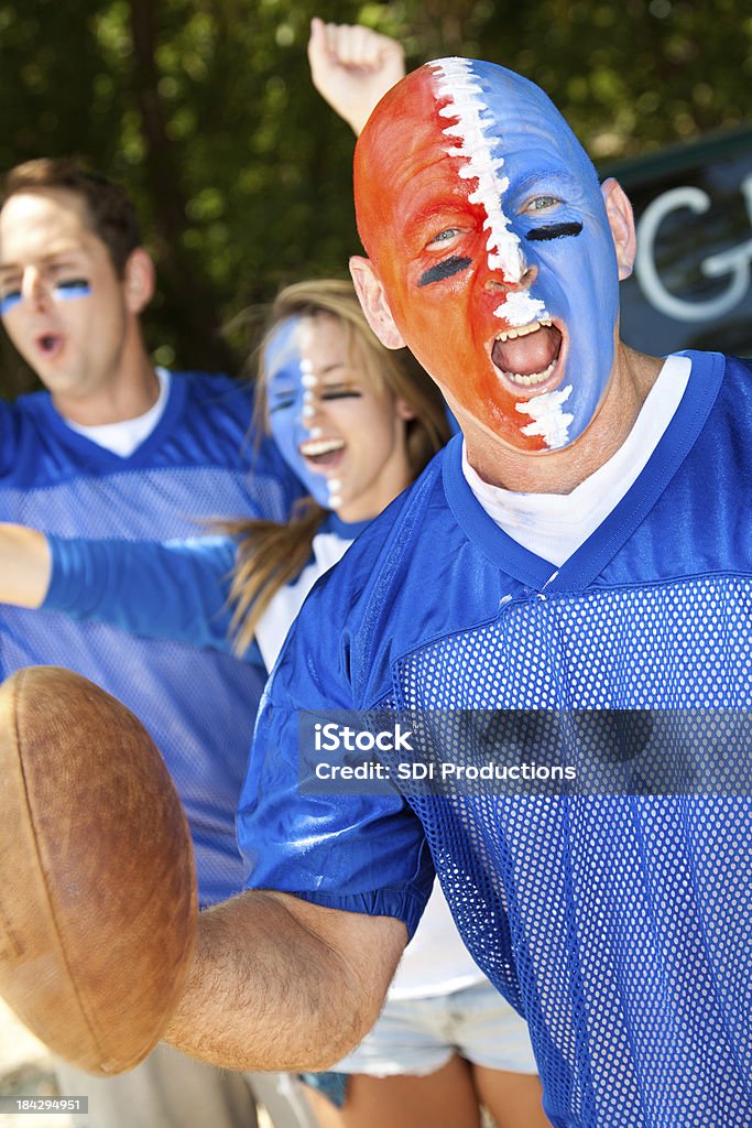 Fan de Football avec visage peint Yelling à une fête d'avant-match - Photo de Ballon de football américain libre de droits