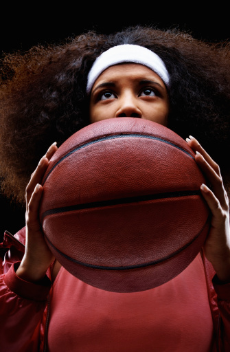 Closeup of young African American woman preparing to throw a basketball