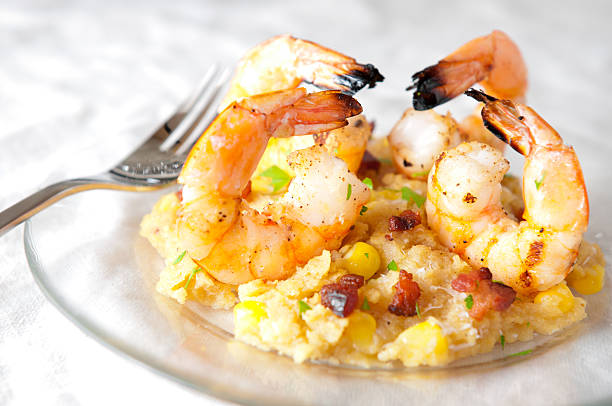 Grilled Shrimp on Parmesan Polenta with Fresh Corn and Bacon stock photo