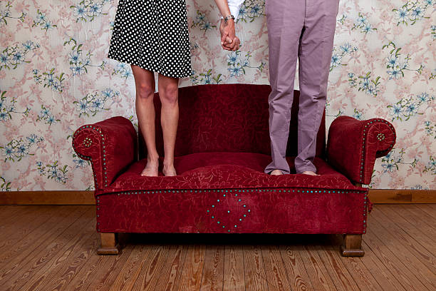 giovane coppia saltando sul divano vecchio - valentines day love nerd couple foto e immagini stock