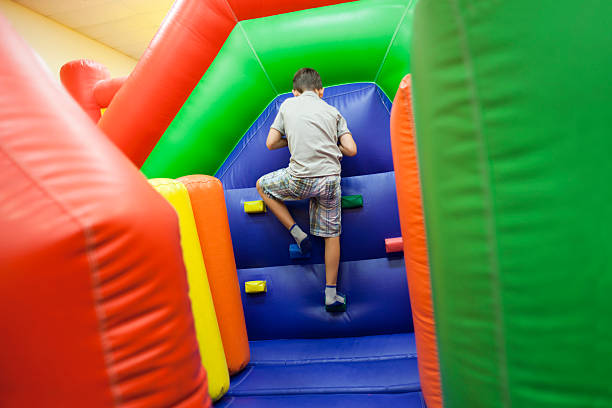 Inflatable Playground Climb Elementary age boy having fun climbing on inflatable playground. mm1 stock pictures, royalty-free photos & images