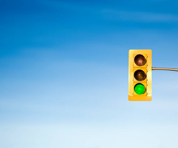 Traffic light green go signal concept Traffic stoplight hanging on the road under a blue sky green light stoplight photos stock pictures, royalty-free photos & images