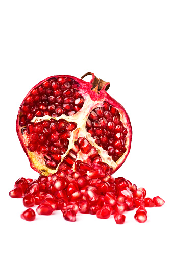 Closeup pomegranate fruit with cut in half sliced and green leaf isolated on white background.