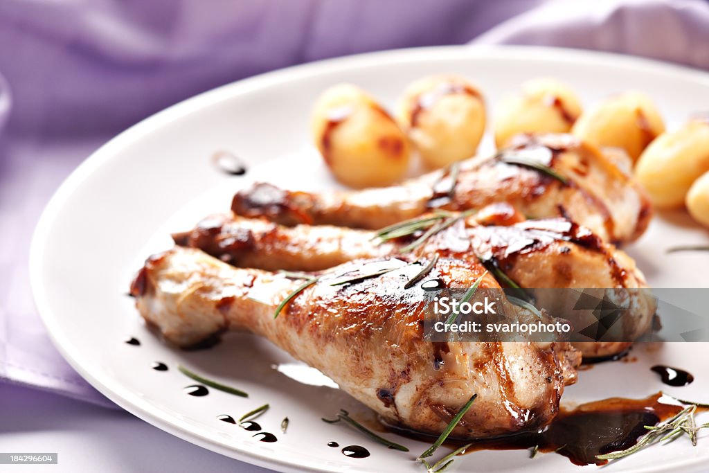 Frango assado em um prato com batatas - Foto de stock de Alecrim royalty-free