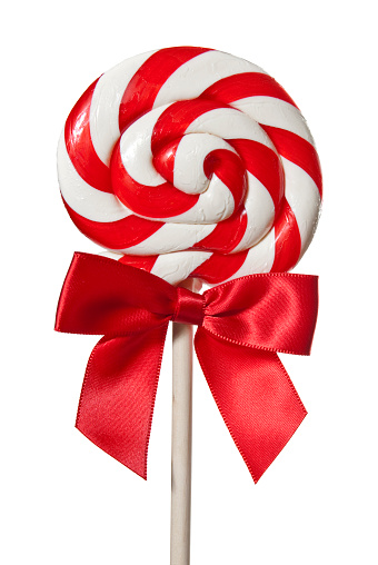 A red and white stripped lollipop on a wooden stick with red bow on a white background.