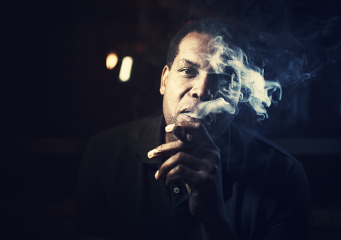 african american man smoking a cigar on a club