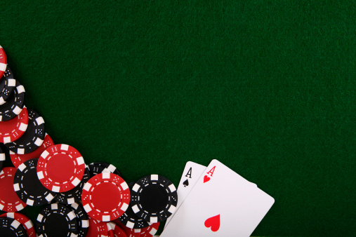 Poker table with pair of aces and chips.