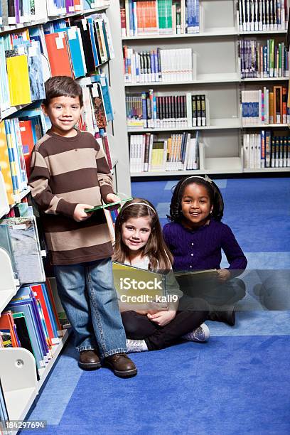 Gran Grupo De Jóvenes En Biblioteca Foto de stock y más banco de imágenes de Niño - Niño, Leer, Biblioteca