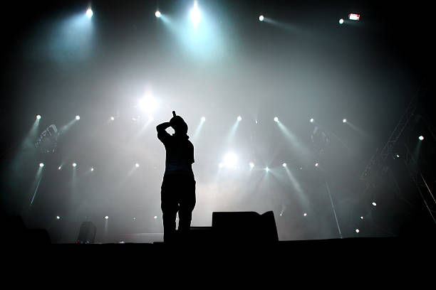 Hip hop singer Silhouette of hip hop singer on stage.  hip hop stock pictures, royalty-free photos & images