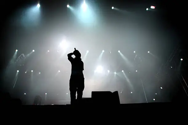 Silhouette of hip hop singer on stage. 