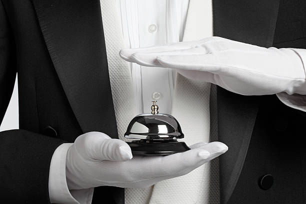 istock Butler holding and about to ring a service bell 184298323