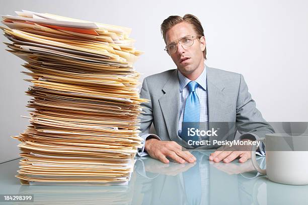 Foto de Empresário Cansado Trabalhador De Escritório Sentado Na Mesa Olhando Papéis e mais fotos de stock de Escrivaninha