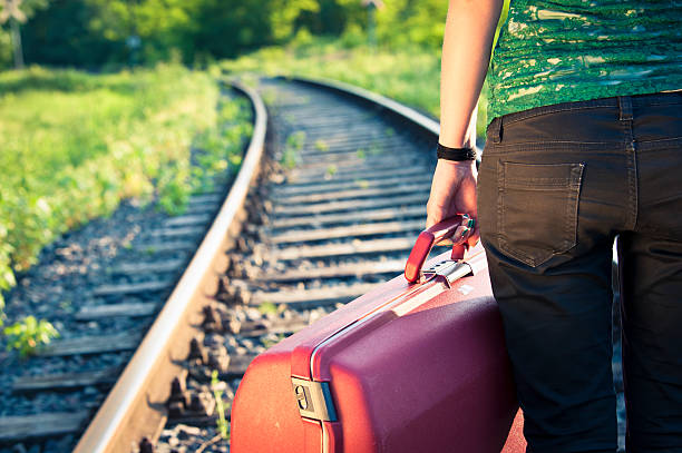 mädchen, die ihr tasche vor der eisenbahn bei sonnenuntergang - leaving loneliness women railroad track stock-fotos und bilder