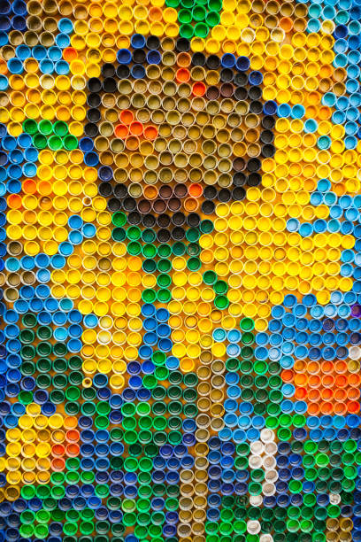 Plastic bottle caps are laid out in a pattern with flowers.