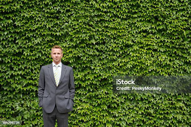 Photo libre de droit de Homme Daffaires Se Tient Devant Le Mur Vert Lierre banque d'images et plus d'images libres de droit de Adulte